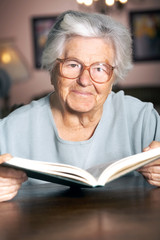 Adorable elderly woman reading a book