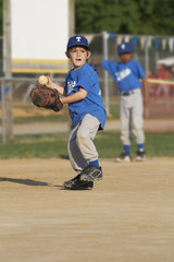 young boy on a baseball field with ball in hand - 5601287