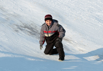 Fototapeta na wymiar happy asian boy on hill in bright winter day