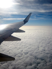 Obraz premium View from aircraft window showing wing and clouds below