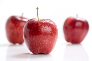 Red apple with water drops on white