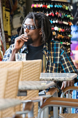 portrait of rasta man, smoking  marijuana on the flea market