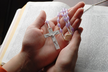 holy bible open with a cross on a hand