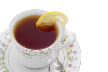 Cup of steeped tea served with lemon on white background.