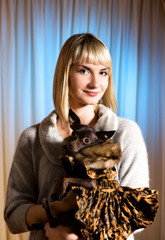 Obraz premium Elegant girl with funny little dog in luxury dog's clothing