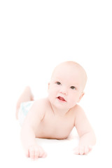 Funny little baby lying on white bed over white background