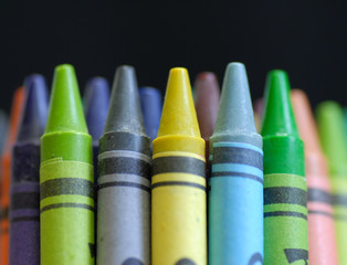 colorful crayons standing up on black background