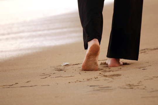 Frau geht entlang des Strandes