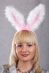 Girl with rabbit ears on gray background