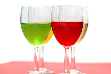 Glasses with drinks of various colours on white