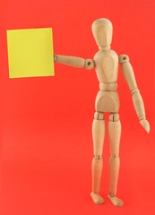wooden figure holding empty adhesive note