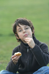 petit gar&ccedil;on avec des lunettes entrain de manger un g&acirc;teau