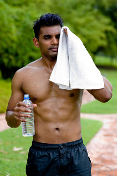 A Well-built Young Man Standing Outside With No Top 