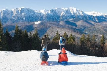 Four people enjoying the fresh air at the mountain. Back view. Winter landscape.