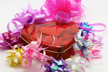 Heart shaped gift box surrounded by colorful ribbons