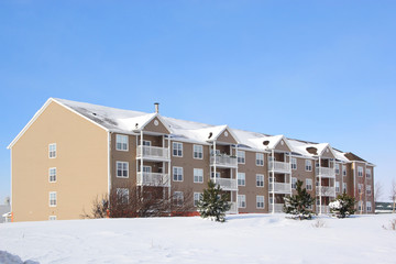 A new apartment building surrounded by a snowy landscape.