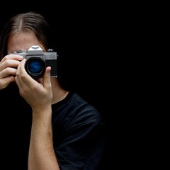 Photographer with an old film camera isolated on black