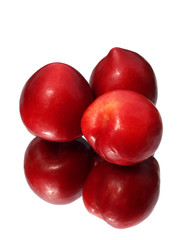 Thre fresh plums with reflection