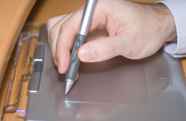 graphical tablet with hand taking pen concept