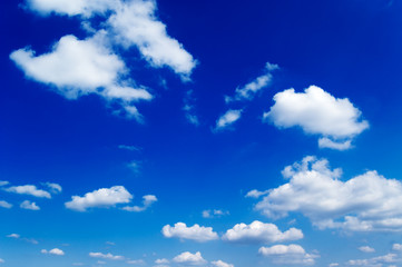 Naklejka na ściany i meble Białe puszyste chmury na niebieskim niebie.