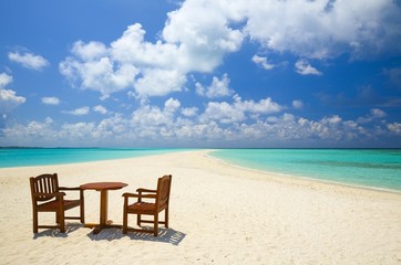 Fototapeta na wymiar Dwa krzesła i jeden tabeli są na rafy, piaszczystej plaży, Malediwy