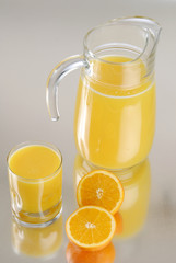 Naklejka na ściany i meble sliced oranges and orange juice on a silver counter top