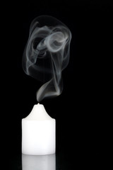 Blown out candle with silky blue smoke
