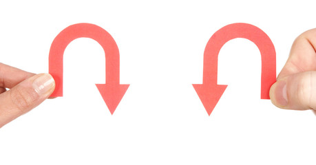 fingers holding arrows pointing down