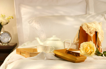 Fototapeta na wymiar Rano herbata w łóżku z czekoladek i białymi prześcieradłami