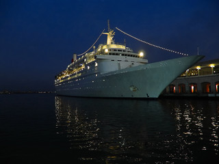 Old ocean liner at the shore blue tint, night view many lights