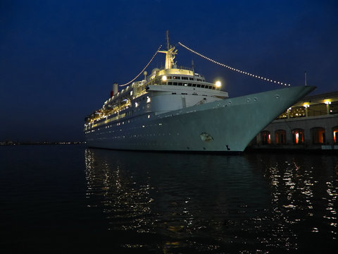 Old ocean liner at the shore blue tint, night view many lights