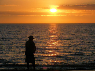 old man fishing at sunset