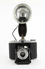 Old photo camera with strobe flash on white background
