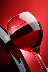 Papier Peint photo Lavable Vin Nature morte avec verre de vin sur fond rouge