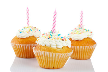 Muffins with candle reflected on white background. Shallow DOF