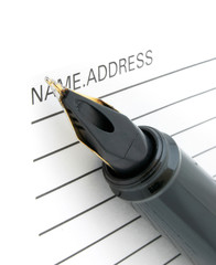 close-up of pen tip and address book
