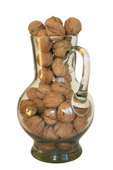 Handful of walnuts in a glass decanter on a white background