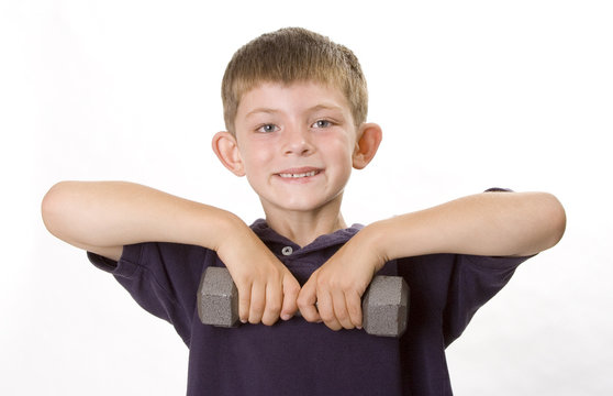 Young boy lifting weights and smiling