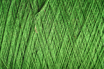 green thread fabric wool yarn wrapped in a spool