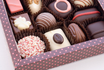 Part of box with chocolate bonbons on white background