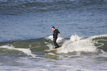 homme en smoking assis sur une planche de surf