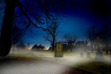 A spooky graveyard at sundown with mist