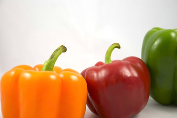 orange red green peppers on a white background