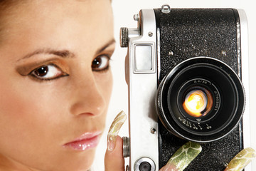 Sexy girl with old photo camera. Focus point on the camera.