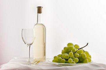 still life, empty bocal, bottle of  white wine and grapes