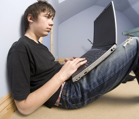13 year old  boy teenager with laptop computer