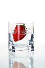 strawberry falling in waterglass