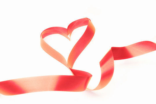 Red ribbon in the shape of heart as a symbol of love