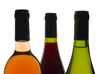 Backlit shot of red, rose and white wine bottles