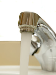 Close-up of head of mixer tap with water running